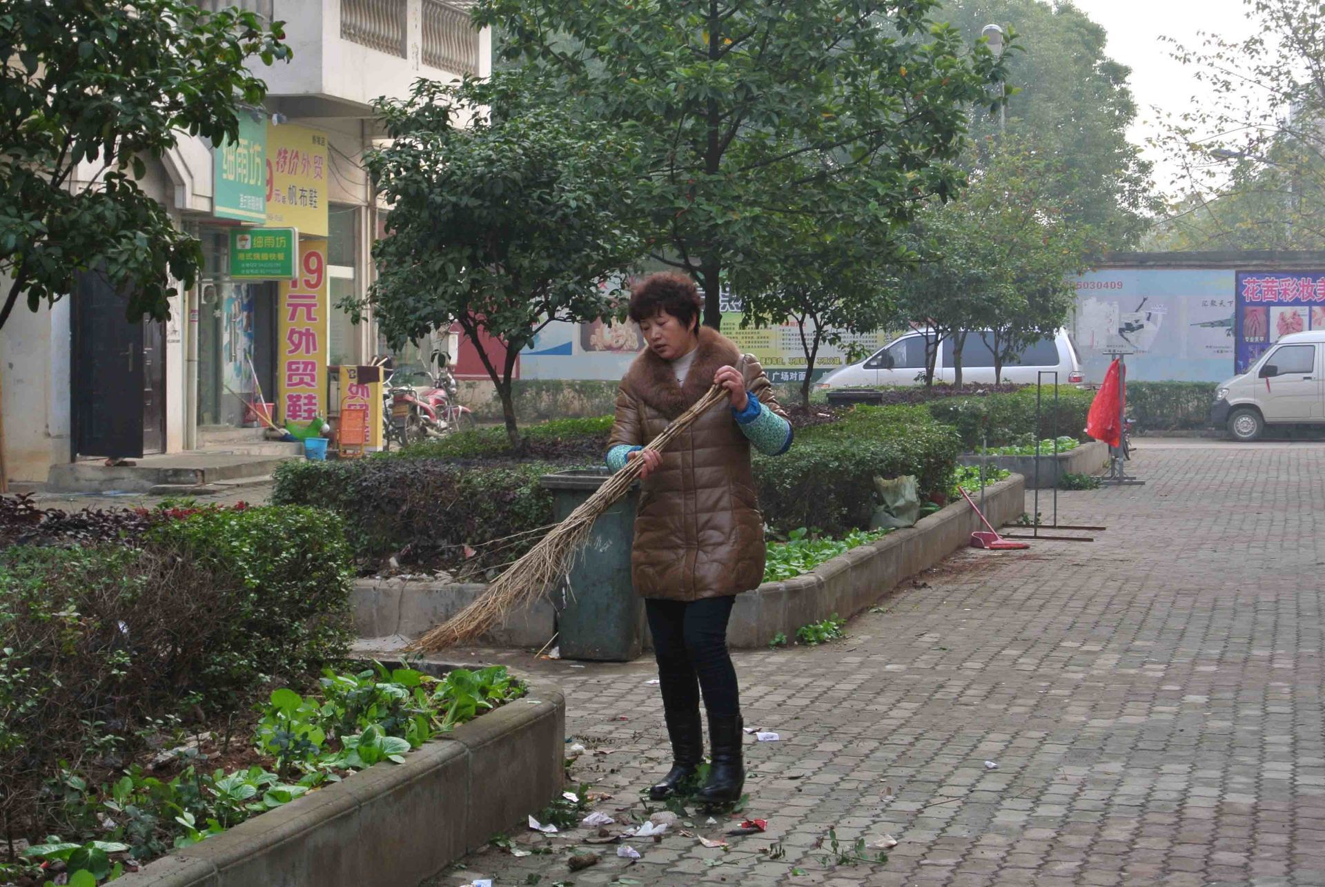 建材公司经理清扫花坛