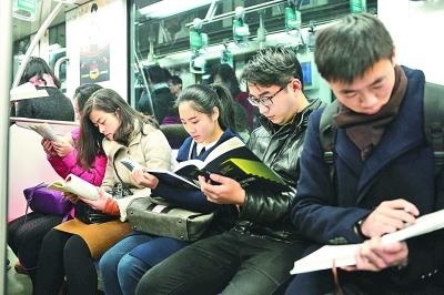 近50名传统阅读爱好者在上海地铁2号线上上演了一场“阅读占领地铁”行动，爱好者们在地铁车厢内静声翻阅图书，呼吁人们养成读书习惯，并倡导社会回归对传统纸质书籍的关注。光明图片