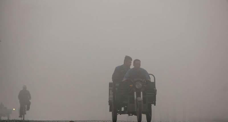 实拍穿越雾霾区的三轮车