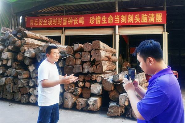 王木匠红木总经理吴丰林（左）介绍产品在选材、工艺上的特色