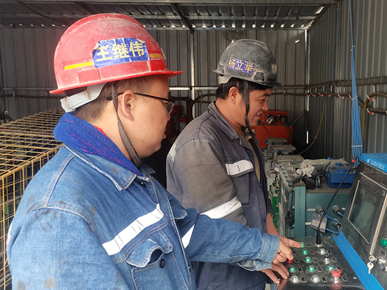 图为王继伟在指导员工使用仪器