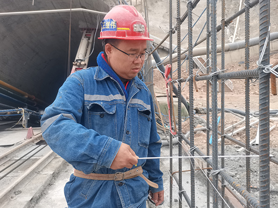 图为王继伟在复核钢筋绑扎间距