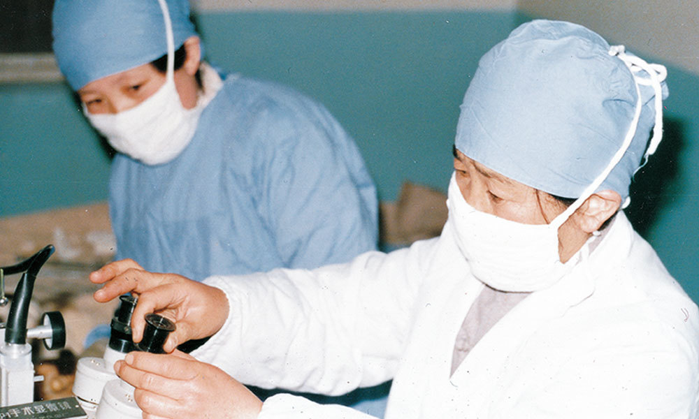 1987年，科研所在河南省首家开展显微输卵管复通术。图为专家仝昭瑾、黄爱萍调试手术显微镜