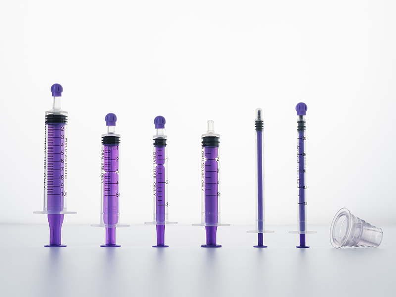 Oral syringe with protective cap and adapter