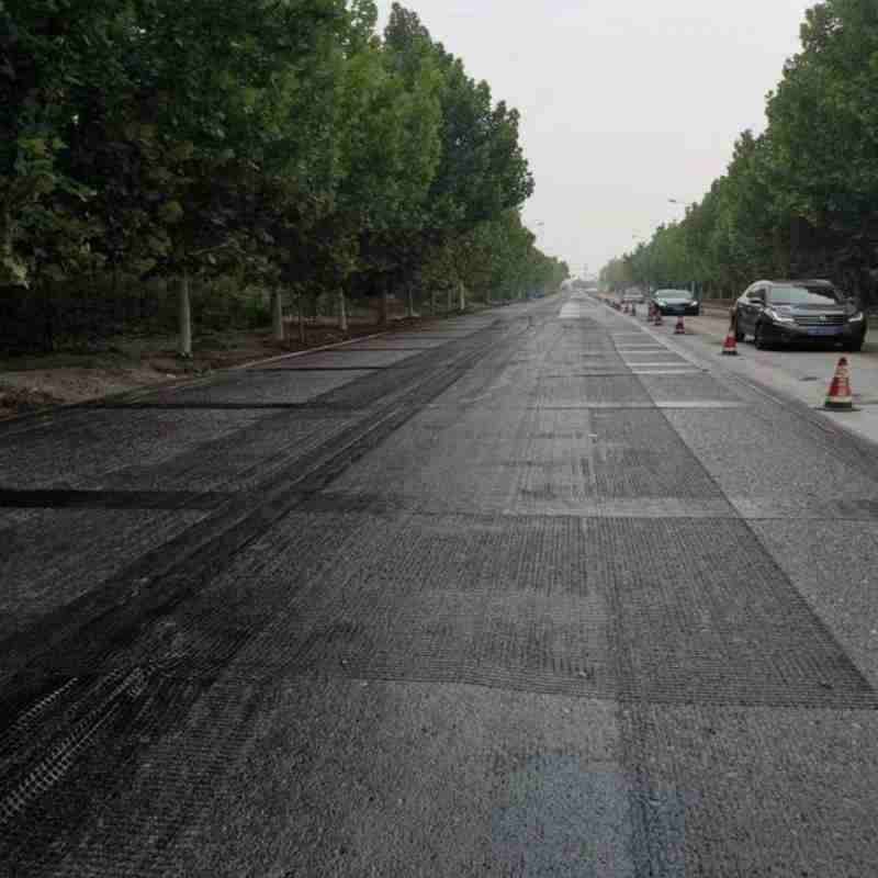 Instalación de geogrid de fibra de vidrio para pavimentación de asfalto.