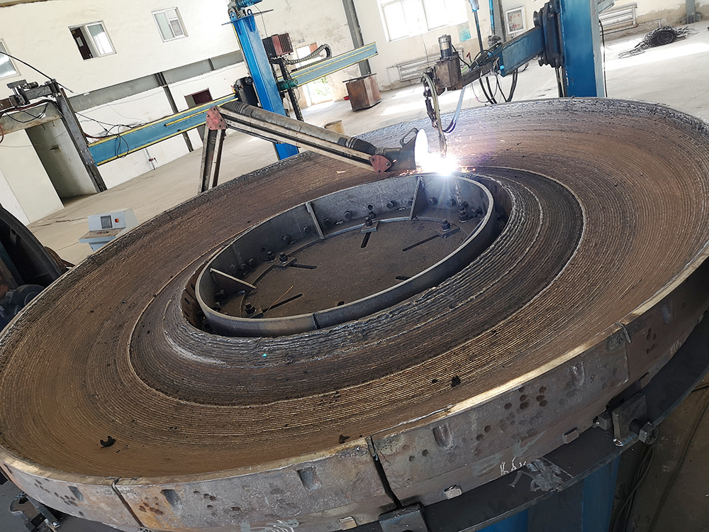 Hardfacing overlay for grinding roller and grinding table