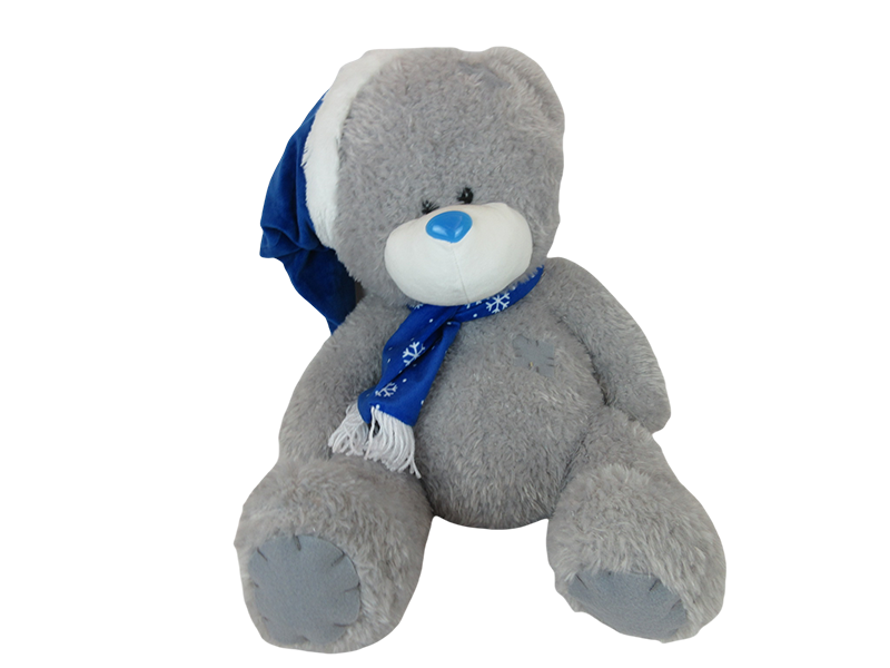 Plush teddy bear in blue hat and scarf