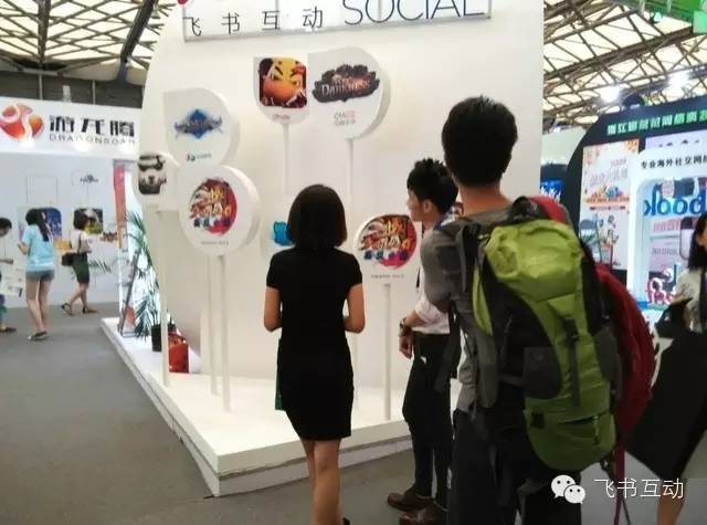 飞书互动展台的工作人员向咨询商家介绍中国游戏出海案例