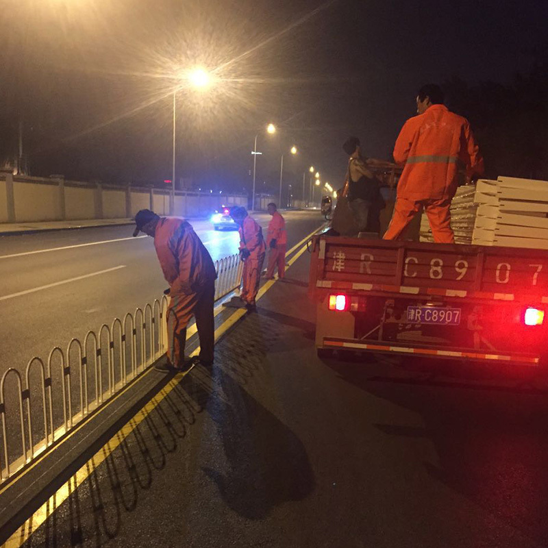 Workers installing guardrails at night