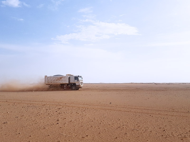 TRUK dump truck is running in interior of the Sahara, the truck still remains stable status.