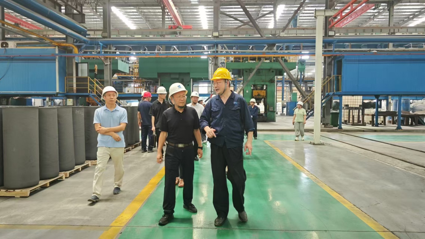 A group of men in hard hats in a factoryDescription automatically generated