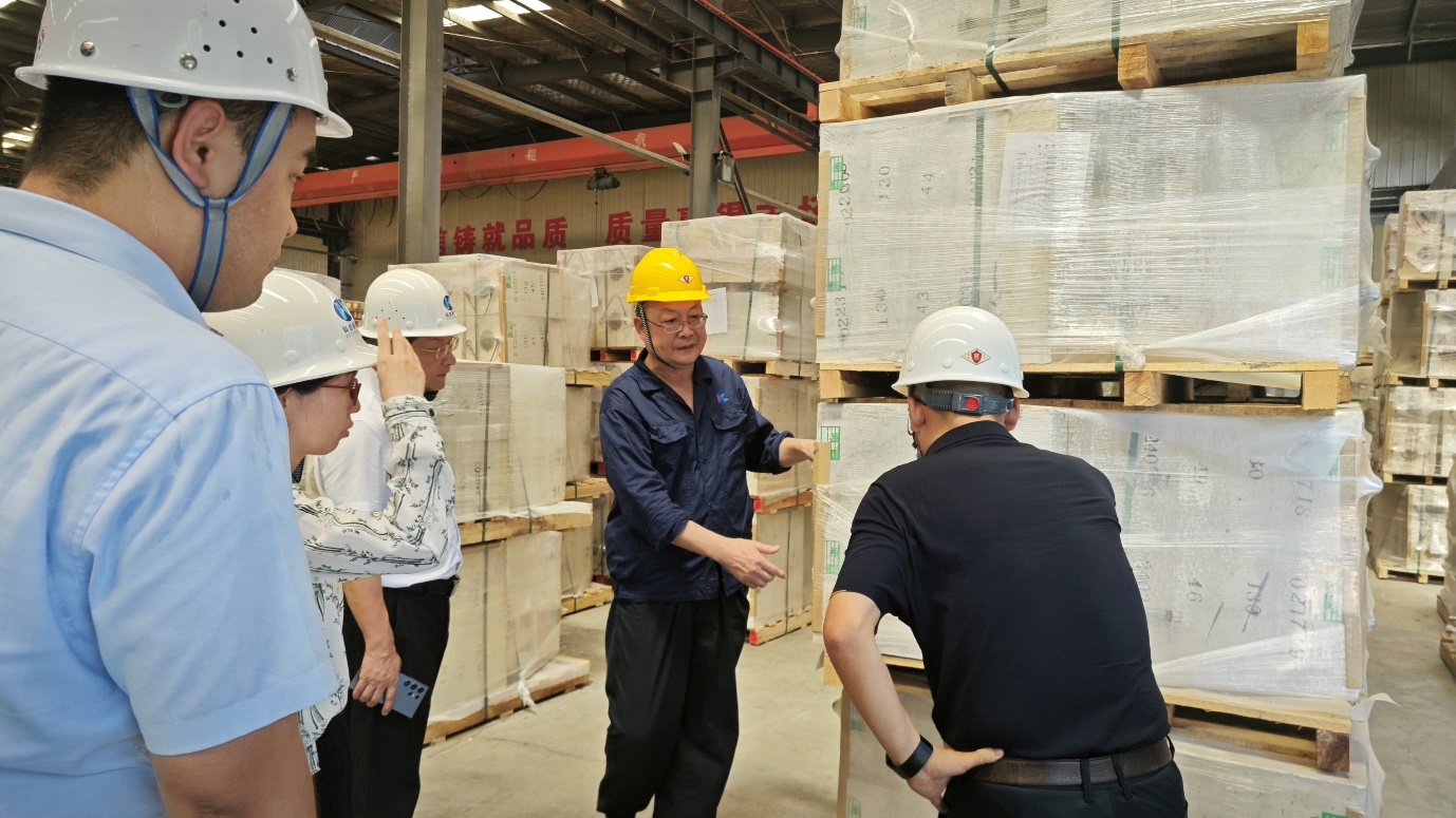 A group of people in hard hats in a warehouseDescription automatically generated