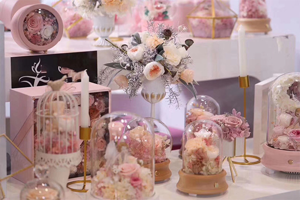 淡粉色永生花展示，搭配玻璃罩、花艺布置和装饰盒，适合婚礼主题